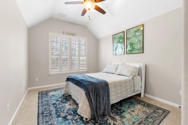 a bed sitting in a bedroom next to a window