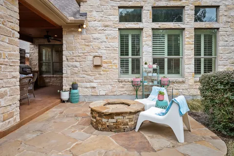 a view of a patio with couple of chairs and a fire pit