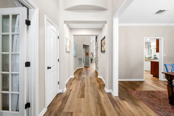 a view of a hallway with wooden floor and staircase