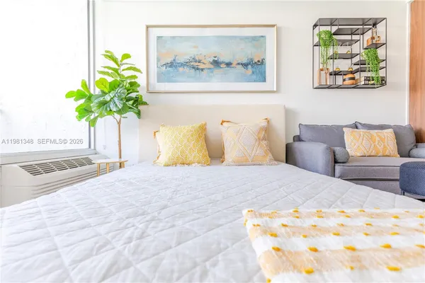 a bedroom with a bed and a painting on the wall