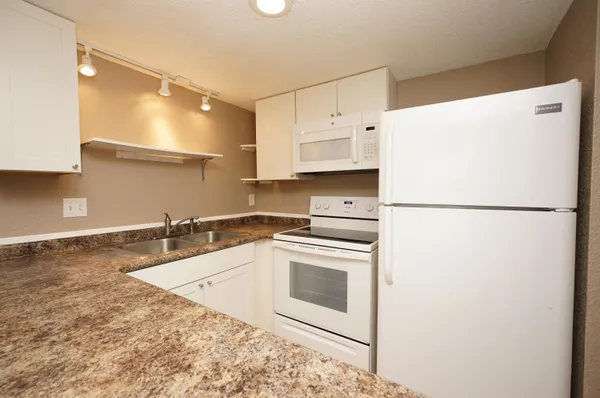 a kitchen with a refrigerator sink stove and cabinets