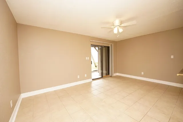 an empty room with closet and a ceiling fan