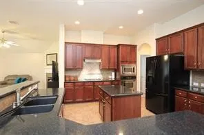 a kitchen with stainless steel appliances granite countertop a refrigerator stove and oven