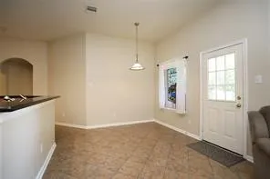 a view of an empty room with window and bathroom