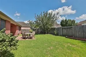 a view of a backyard with table and chairs and potted plants with wooden fence