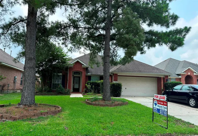 a front view of a house with a garden and tree