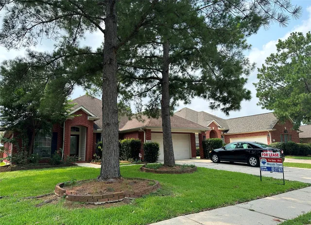 a front view of a house with a garden and trees