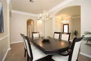 a view of a dining room with furniture and a chandelier