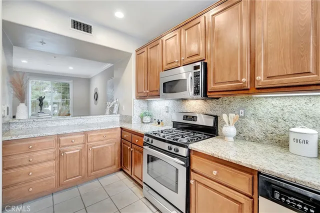 a kitchen with granite countertop white cabinets sink and stainless steel appliances