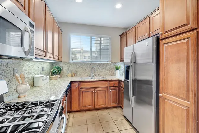 a kitchen with stainless steel appliances granite countertop a refrigerator sink and stove