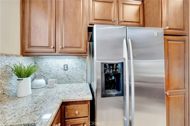 a kitchen with a refrigerator and potted plant