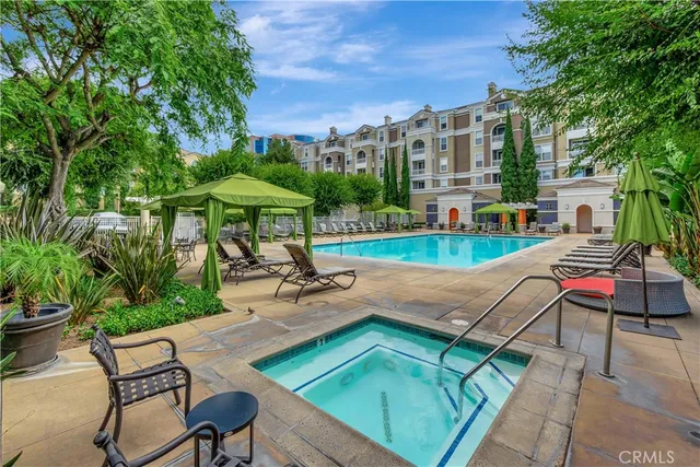 a view of a swimming pool with lawn chairs under an umbrella