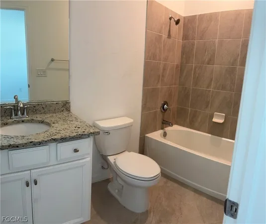 a bathroom with a granite countertop toilet a sink and bathtub