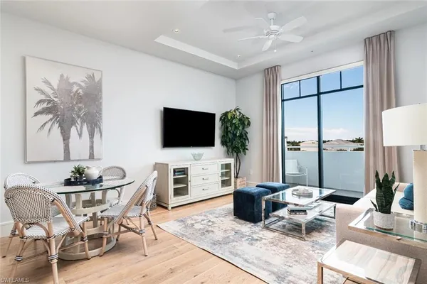 a living room with furniture a flat screen tv and a large window
