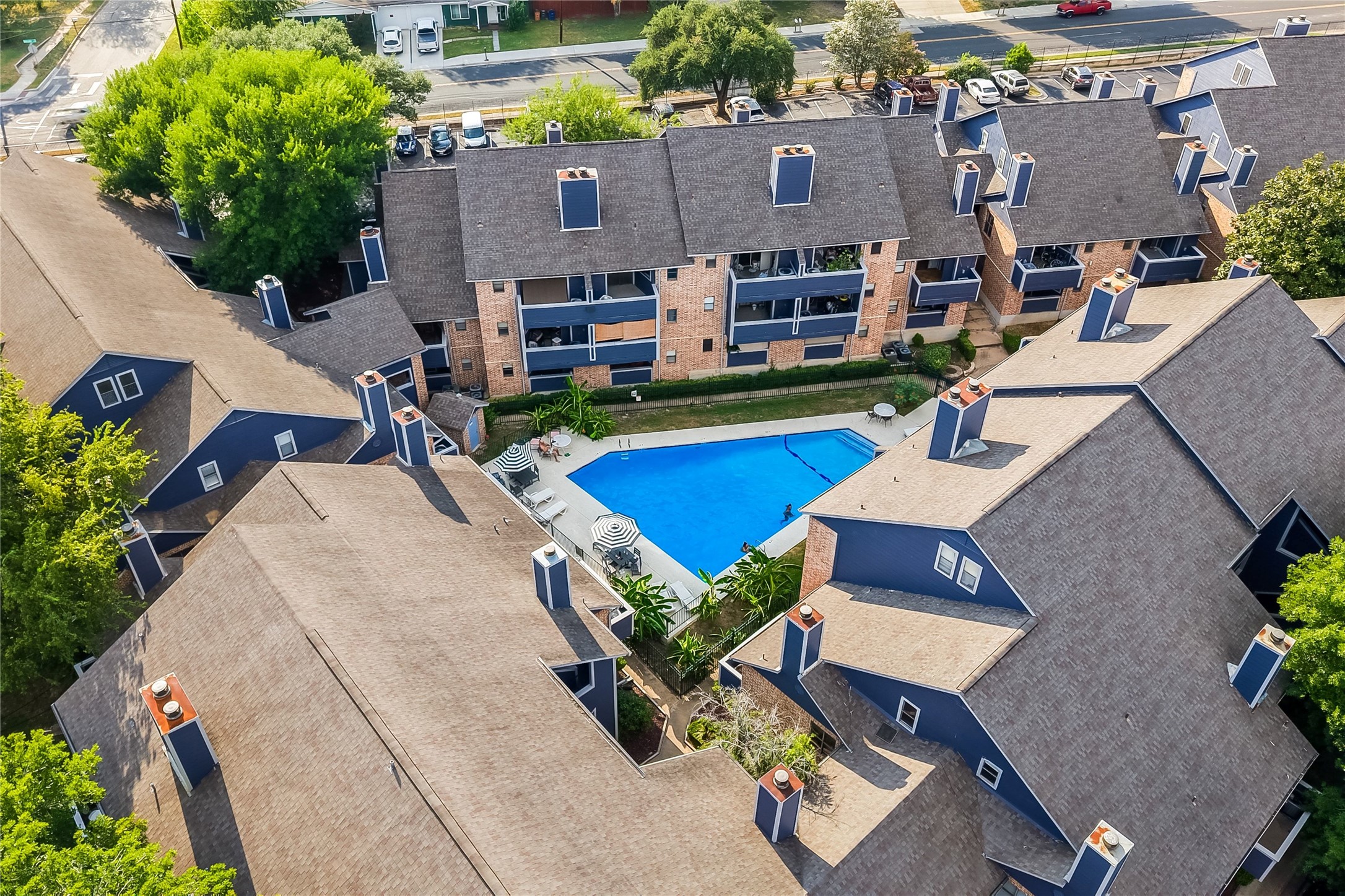 2500 Burleson Road, Unit 609 Austin, TX 78741 - Photo 29 of 32 An aerial perspective reveals a vibrant community pool nestled among multi-story residences, offering a refreshing retreat.