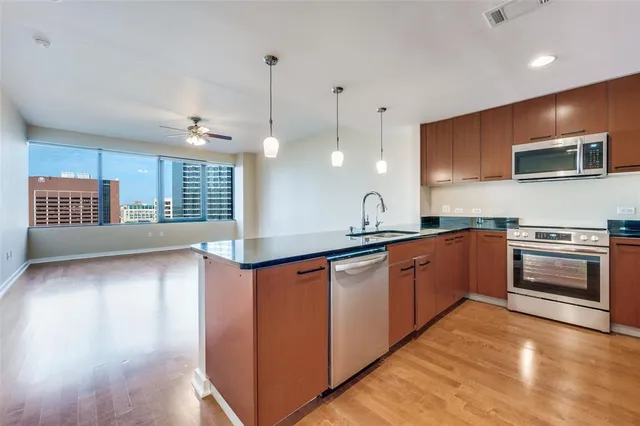 a kitchen with stainless steel appliances granite countertop a stove a sink and a refrigerator