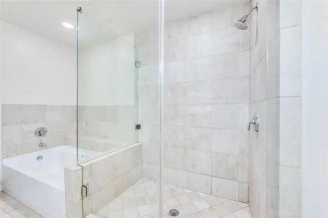 a white bath tub sitting next to a white sink and a shower
