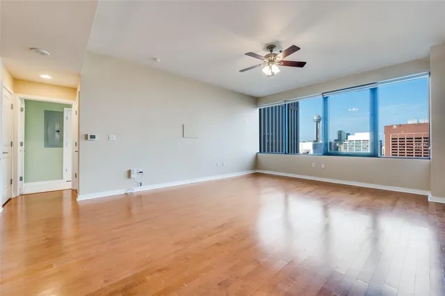 a view of a livingroom with a ceiling fan window and wooden floor