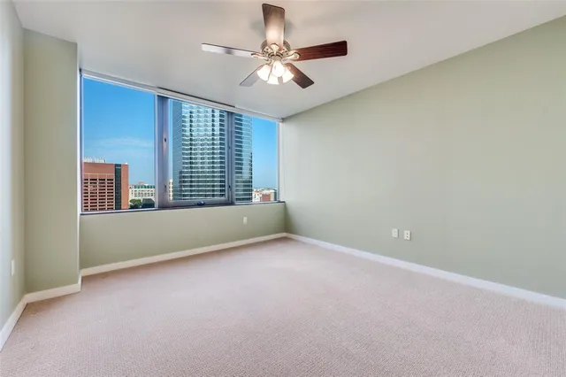 an empty room with windows and fan