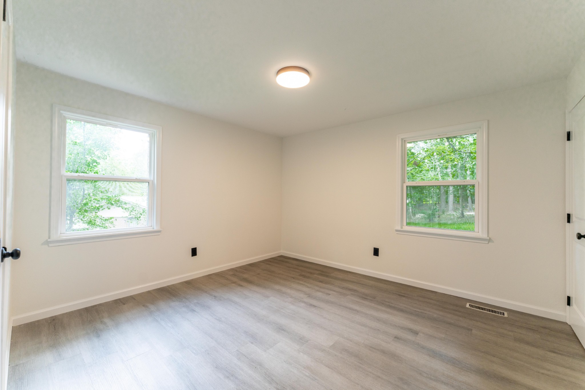 316 Kerrigan Road Crossville, TN 38555 - Photo 9 of 19 an empty room with wooden floor and windows