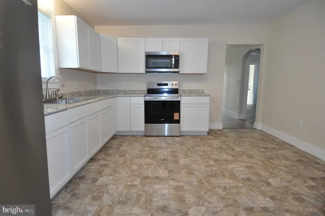 a kitchen with granite countertop a stove top oven a sink and a granite counter tops