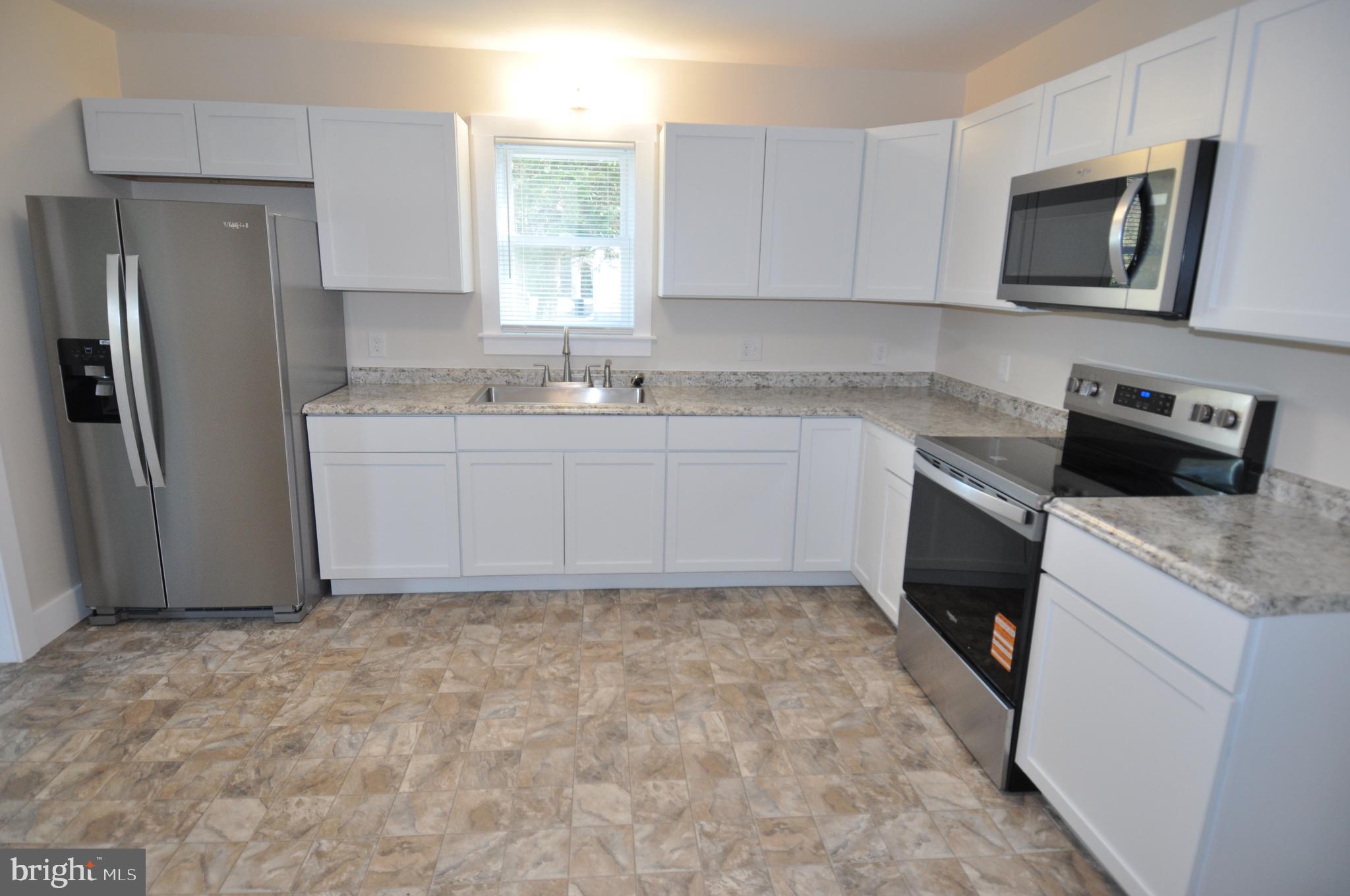 1529 Unionville Road Pocomoke City, MD 21851 - Photo 30 of 33 a kitchen with stainless steel appliances granite countertop a refrigerator sink and microwave