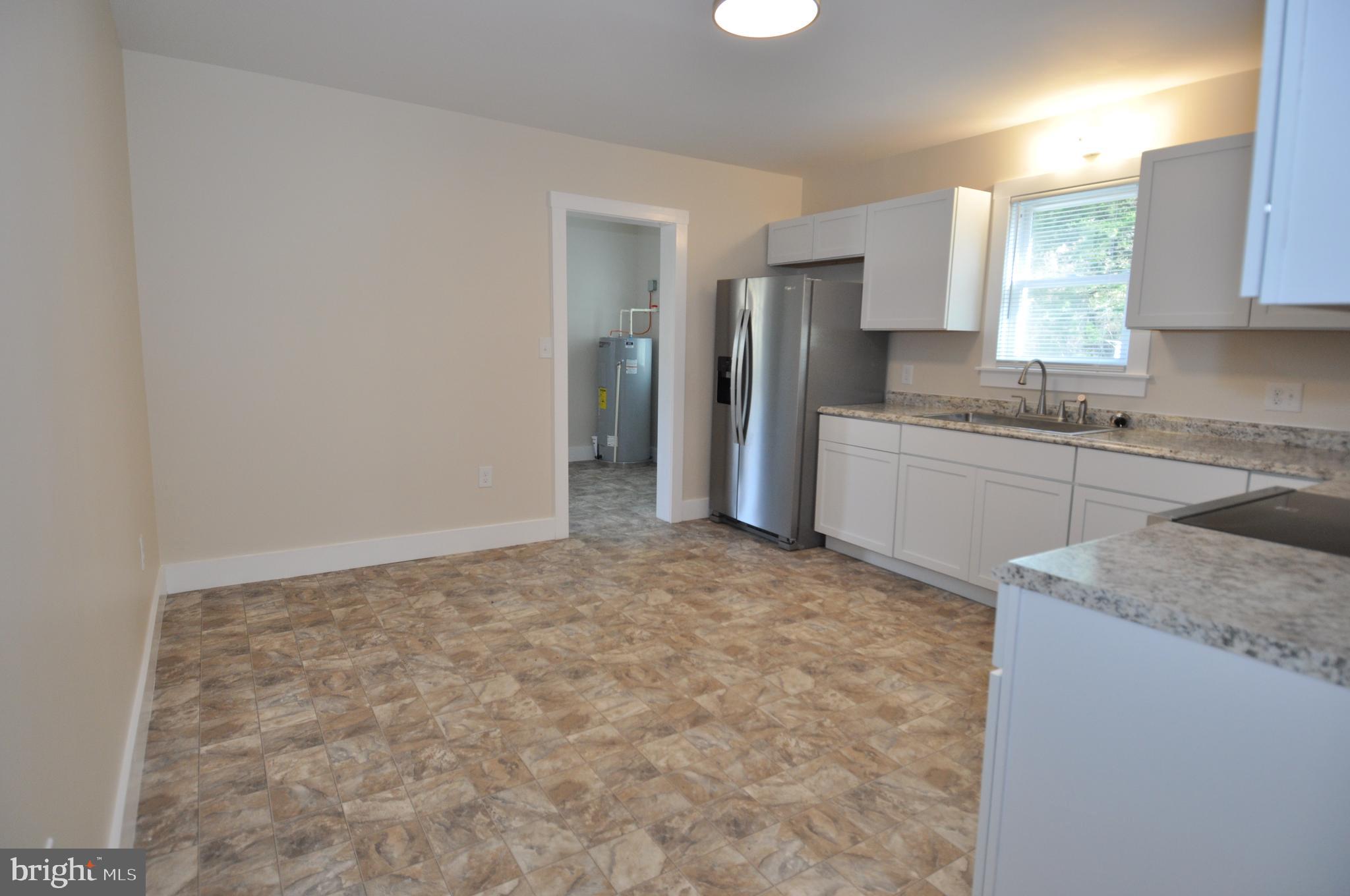 1529 Unionville Road Pocomoke City, MD 21851 - Photo 31 of 33 a kitchen with granite countertop a sink stove and refrigerator
