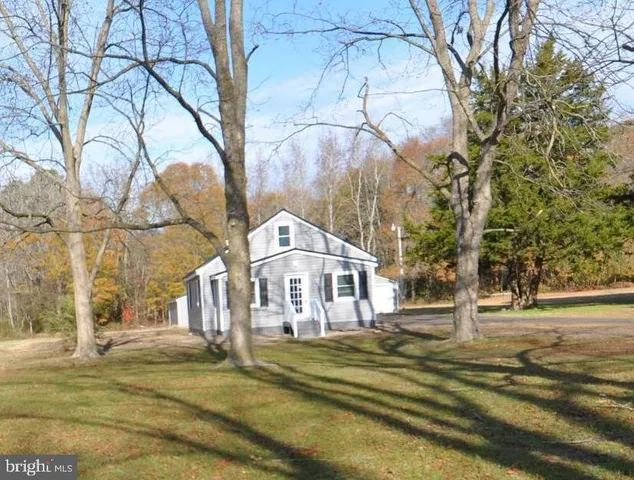 a view of a large house with large trees and playing area