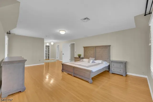 a view of a hallway with wooden floor and chandelier