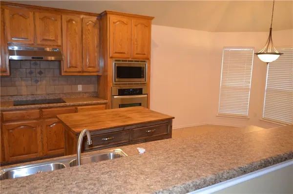 a kitchen with stainless steel appliances granite countertop a sink and a refrigerator