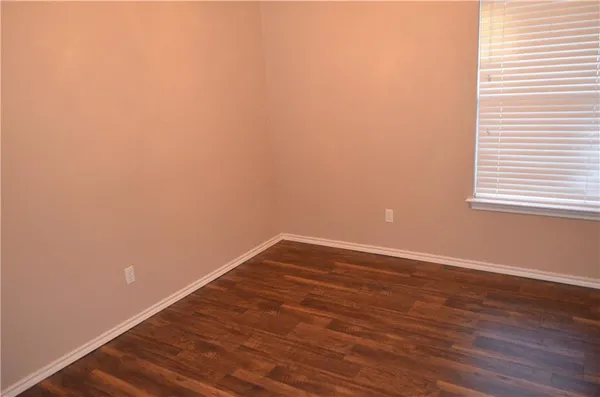 a view of a small space with wooden floor and a window