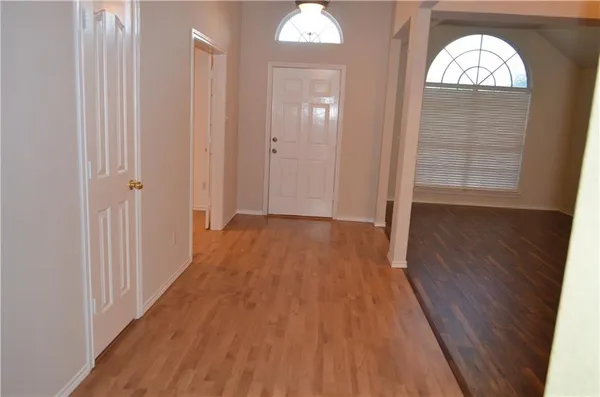 a view of a room with wooden floor and chandelier