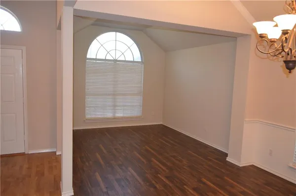a view of a room with wooden floor and chandelier