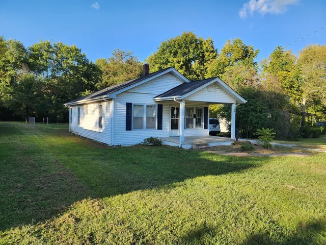 a view of a house with a yard patio and swimming pool