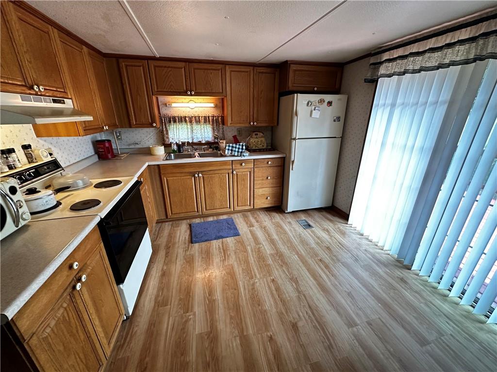 108 Francis Road Perryopolis, PA 15473 - Photo 6 of 20 a kitchen with refrigerator a stove a sink and a window