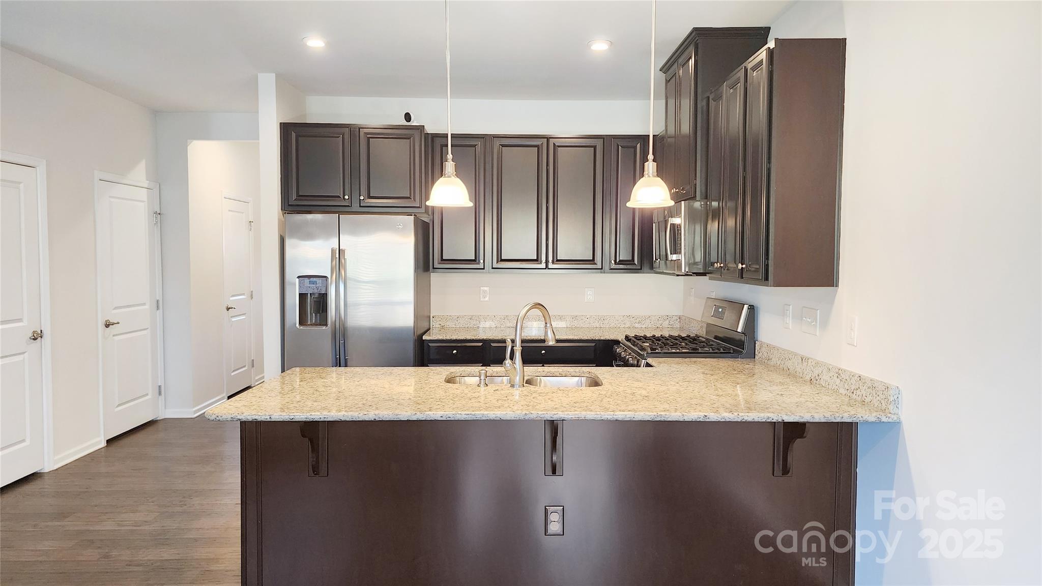 11044 Telegraph Road Northwest Concord, NC 28027 - Photo 6 of 25 a kitchen with kitchen island granite countertop a sink refrigerator and cabinets