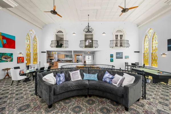 a living room with furniture kitchen view and a large window