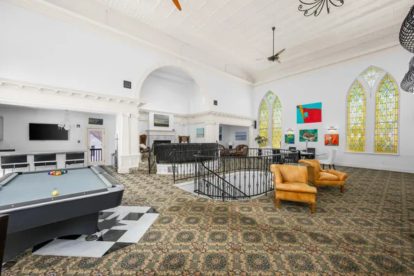 a large kitchen with stainless steel appliances granite countertop a stove top oven a sink dishwasher a dining table and chairs with wooden floor