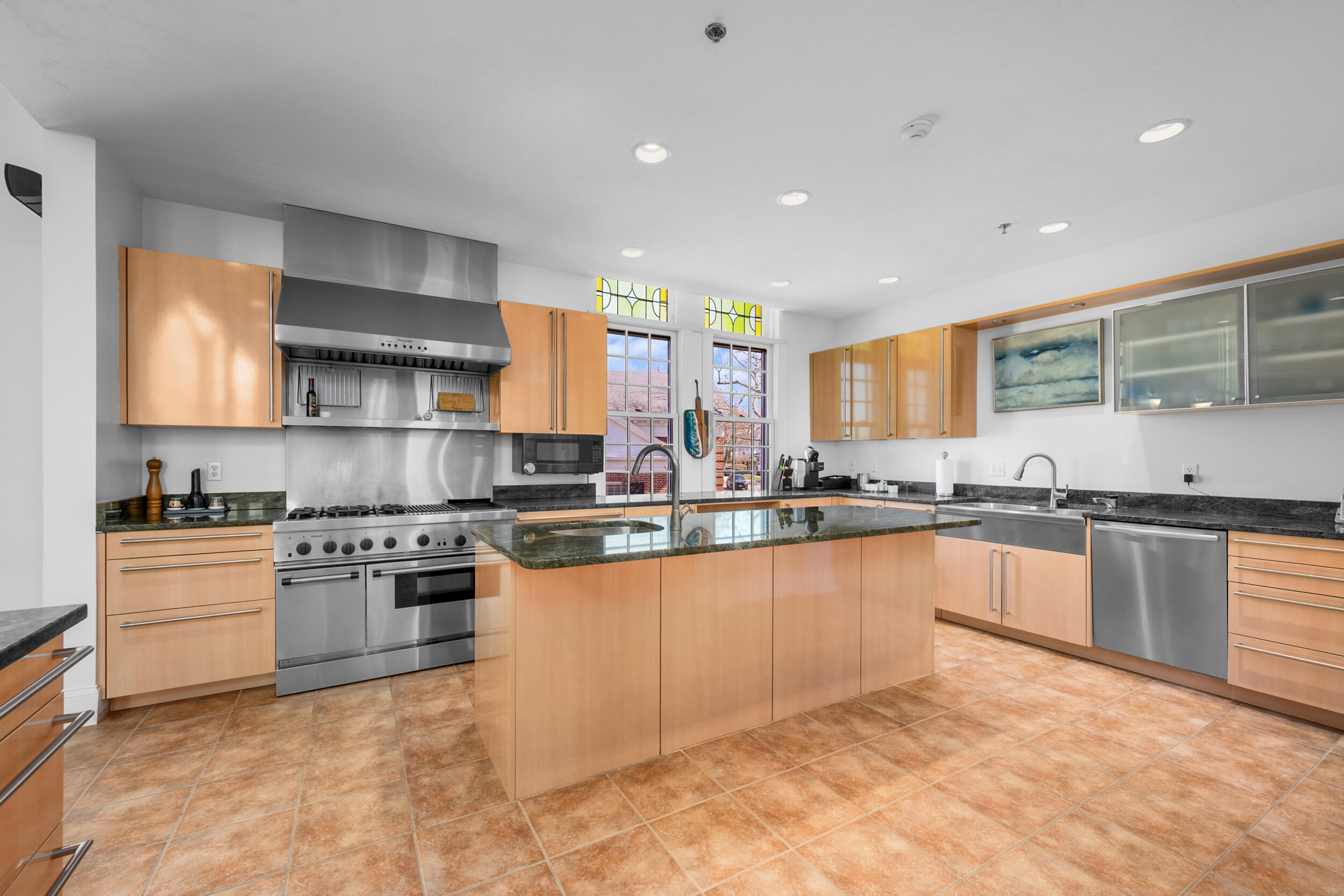 143 Main Street Sandwich, MA 02563 - Photo 20 of 39 a large kitchen with stainless steel appliances granite countertop a stove top oven a sink dishwasher a dining table and chairs with wooden floor
