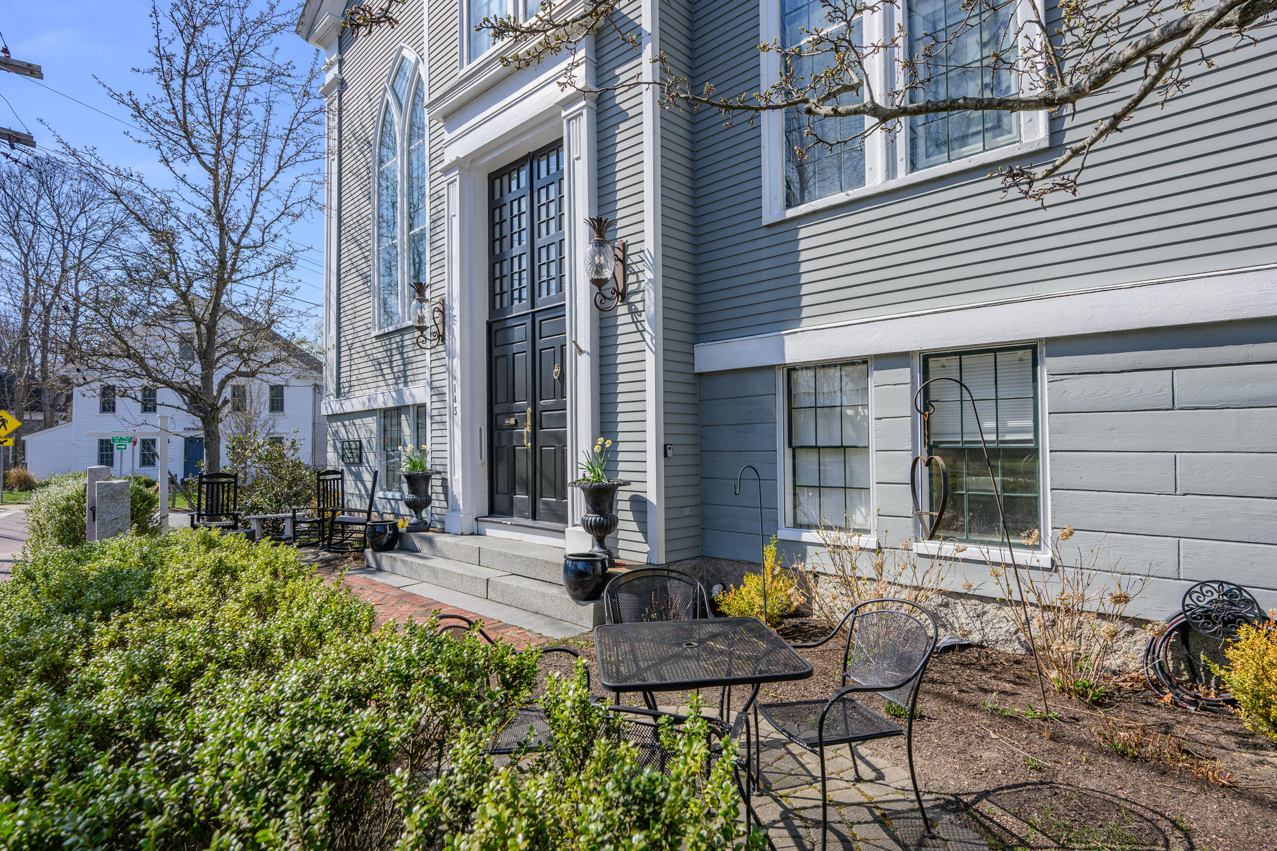 143 Main Street Sandwich, MA 02563 - Photo 8 of 39 a view of a brick house with chairs and table in a patio