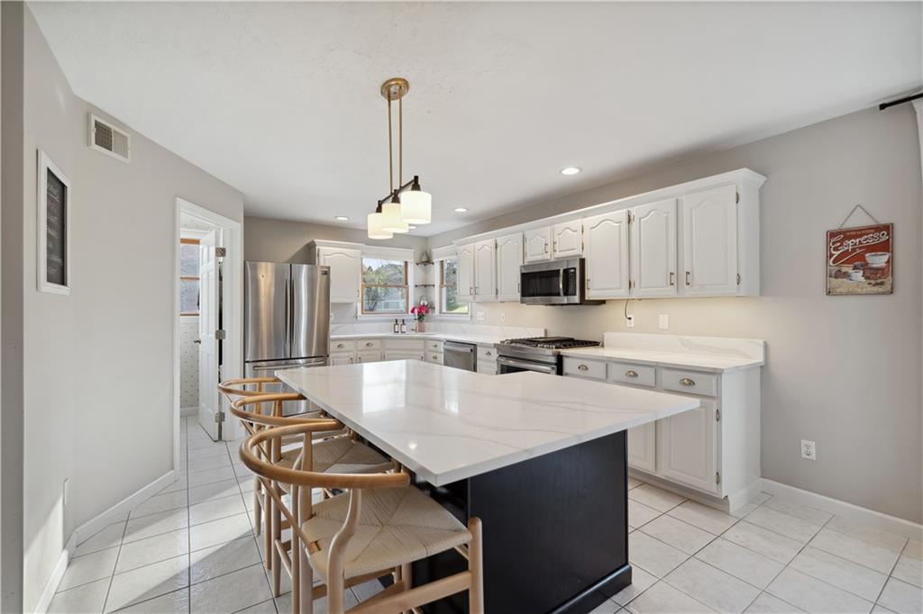 3018 White Pine Drive Gibsonia, PA 15044 - Photo 7 of 38 a kitchen with stainless steel appliances granite countertop a sink a stove a refrigerator cabinets and a dining table