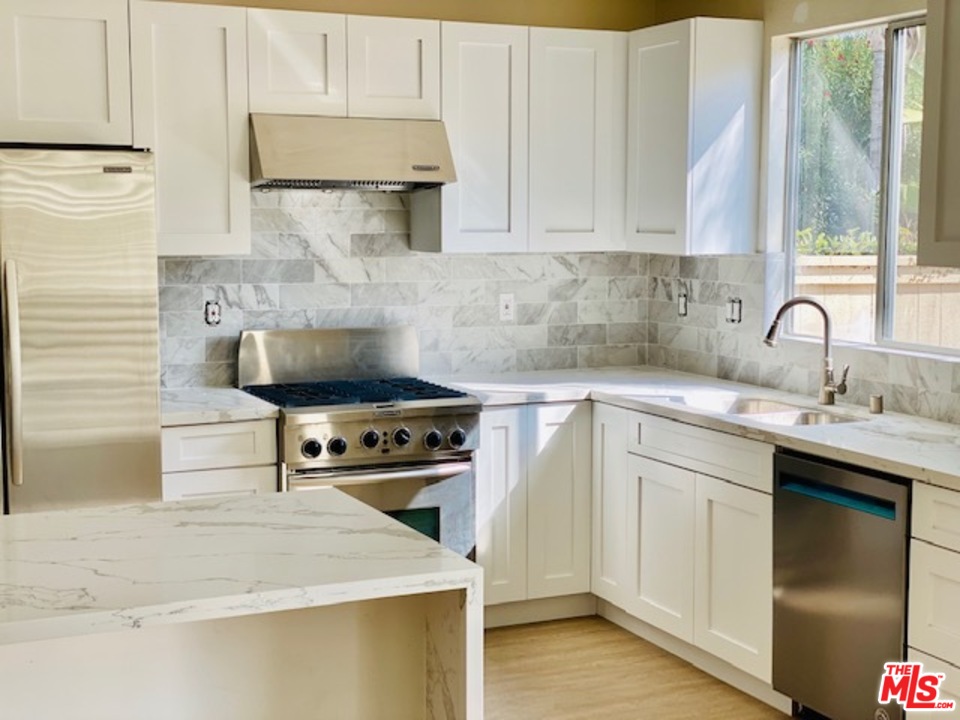 a kitchen with stainless steel appliances a stove sink and cabinets