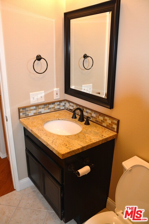16 Nebraska Irvine, CA 92606 - Photo 6 of 18 a bathroom with a granite countertop sink and a mirror
