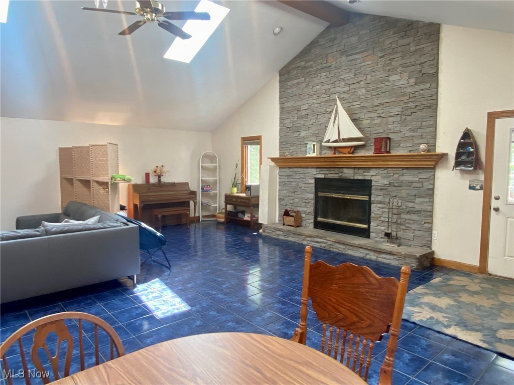 1568 Sunview Road Cleveland, OH 44124 - Photo 5 of 50 Tiled living area featuring ceiling fan, a skylight, a fireplace, high vaulted ceiling, and beam ceiling
