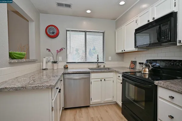 a kitchen with stainless steel appliances granite countertop a sink stove top oven and microwave