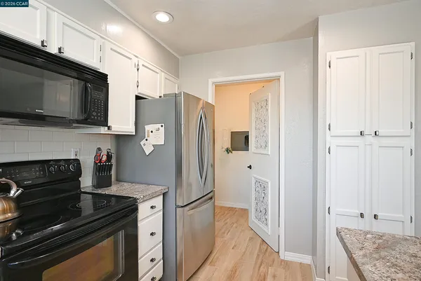 a kitchen with stainless steel appliances granite countertop a refrigerator stove and microwave