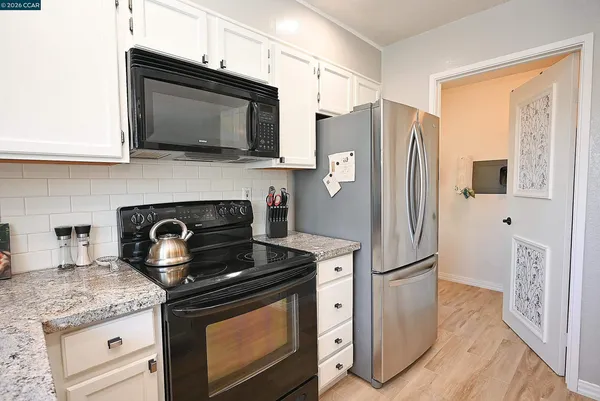 a kitchen with stainless steel appliances granite countertop a stove microwave and refrigerator