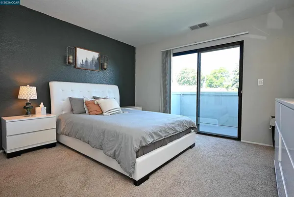 a bedroom with a bed lamp and window