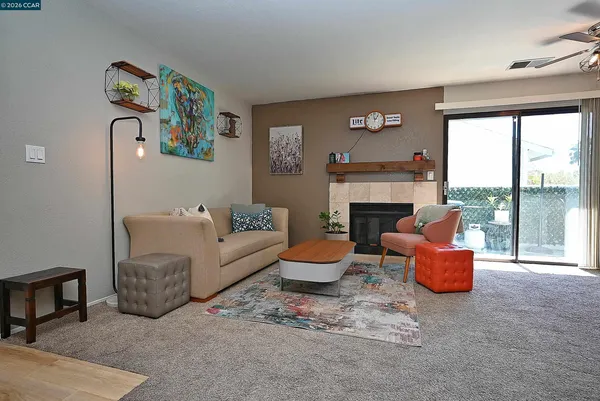 a living room with furniture a fireplace and a floor to ceiling window