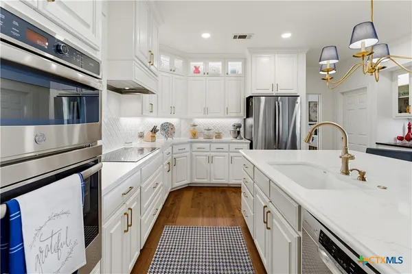 a kitchen with stainless steel appliances granite countertop a stove and cabinets